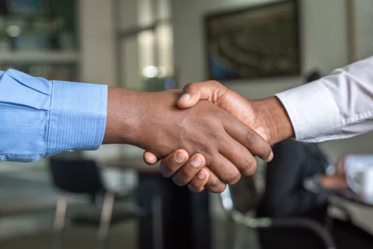 Two men shaking hands and building a strong referral network.
