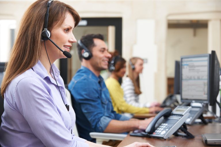 A woman talking on a headset in a call center, representing call center outsourcing.